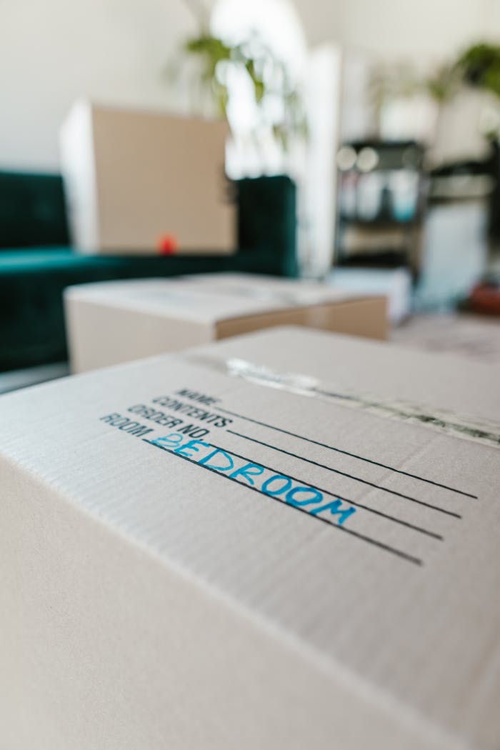 services-01 Packed cardboard box labeled 'Bedroom' indoors, ready for moving.